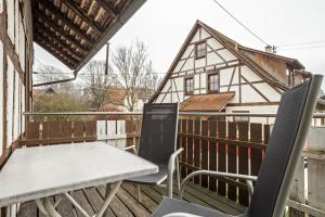 a table and chairs on a balcony with a house at Ferienwohnung Nr 3 in Deggenhausertal