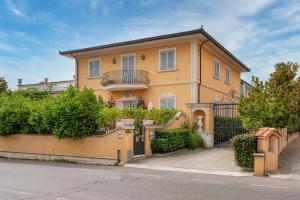 a yellow house with a gate and bushes at Villa Manuela Flat in Chiesina Uzzanese