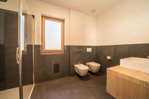 a bathroom with a sink and a toilet and a shower at Apt Lärche - Nockerhof in Andrian
