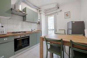a kitchen with a wooden table and chairs at A due passi dalle terme e dal lago in Trescore Balneario