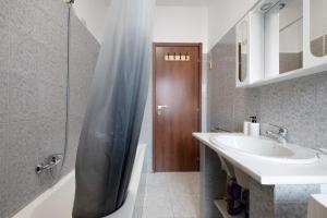 a bathroom with a shower curtain and a sink at A due passi dalle terme e dal lago in Trescore Balneario +21 photos