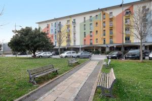 two benches in a park in front of a building at A due passi dalle terme e dal lago in Trescore Balneario