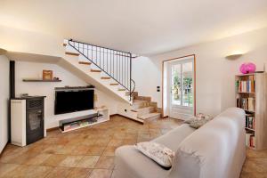 a living room with a couch and a tv at Rustico alle Fornare in Torri del Benaco