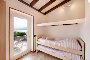 a bedroom with a bunk bed and a window at Rustico alle Fornare in Torri del Benaco