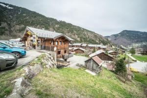 a mountain cabin with cars parked in a parking lot at Sherpa - 10 pers in Saint-Jean-d'Aulps