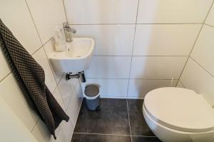 a bathroom with a toilet and a sink at Krummes Häusschen an der Nordsee in Großheide +16 photos