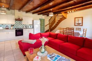 a living room with a red couch and a kitchen at Domaine de Lestroué - Belle-île in La Vraie-Croix
