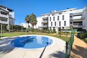 a large swimming pool in front of a building at Apartamento Punta Candor in Rota