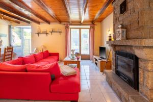 a living room with a red couch and a fireplace at Domaine de Lestroué - Belle-île in La Vraie-Croix