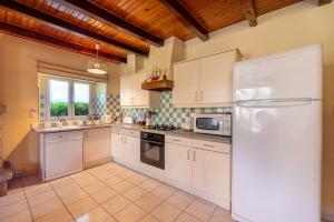 a kitchen with white cabinets and a white refrigerator at Domaine de Lestroué - Belle-île in La Vraie-Croix +11 photos