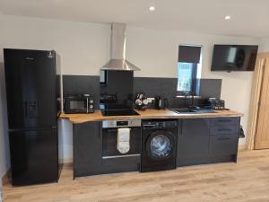 a kitchen with a refrigerator and a washing machine at Temuka Lodge in Glenurguhart