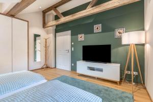 a bedroom with a bed and a tv on a green wall at Ferienwohnung Kist in Sasbachwalden