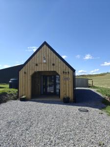 a large wooden barn with a large door at Temuka Lodge in Glenurguhart +26 photos