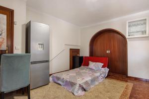 a room with a refrigerator and a bed in it at Estúdio entre Porto e Aveiro in Carregosa +20 photos