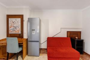 a kitchen with a refrigerator and a table and a chair at Estúdio entre Porto e Aveiro in Carregosa