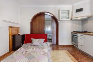 a kitchen with a red chair in a room at Estúdio entre Porto e Aveiro in Carregosa