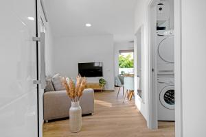 a living room with a couch and a washer and dryer at Flamboyan 3 in Telde