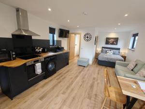 a kitchen and living room with a couch and a table at Temuka Lodge in Glenurguhart