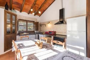 a kitchen with a table and a refrigerator at Finca Liarte in Murcia