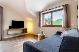a living room with a couch and a tv at Furnerhof Apt Olpenglühn in Collepietra