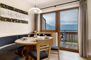 a dining room with a table and a large window at Furnerhof Apt Olpenglühn in Collepietra