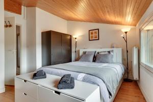 a bedroom with a large bed and a wooden ceiling at A Bordeaux, Climatisée avec billard in Le Bouscat