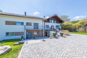 a house with a stone driveway in front of it at Ferienwohnung Rudi in Taching am See