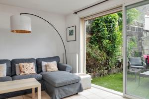 a living room with a couch and a sliding glass door at A Bordeaux, Climatisée avec billard in Le Bouscat