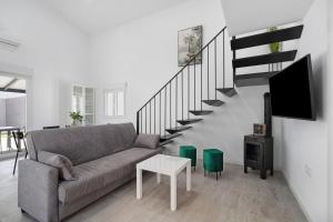 a living room with a couch and a staircase at Alce piscina climatizada in Chiclana de la Frontera
