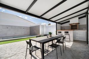 a kitchen and dining room with a table and chairs at Alce piscina climatizada in Chiclana de la Frontera