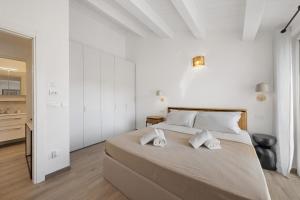 a white bedroom with a large bed with two white towels at Cinema Boutique Apartment Sestri in Sestri Levante