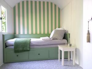 a bed with a green headboard in a room at Freilandhof in Ötisheim