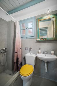 a bathroom with a yellow toilet and a sink at Ammos 1 in Serifos Chora