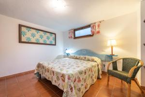 a bedroom with a bed and a chair at Villa Maladroxia in Maladroscia