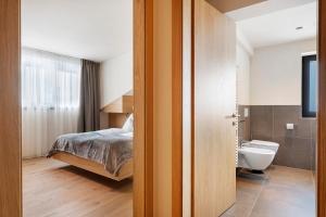 ein Schlafzimmer mit Bett und ein Badezimmer mit Toilette in der Unterkunft Hotel Murrer relaxe.nature.gusto in Sarntal + 290 Fotos