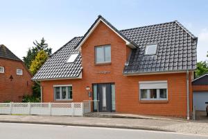 a red brick house with a black roof at Ferienhaus Siegfried in Niebüll