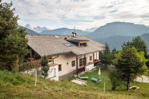 a house on a hill with mountains in the background at Apartment Funtnatsch in Laion