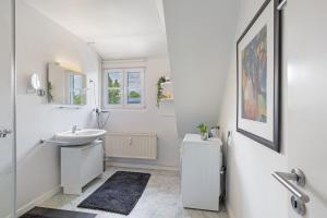 a white bathroom with a sink and a toilet at Schöne Dachgeschoss Wohnung in Warstein +24 photos