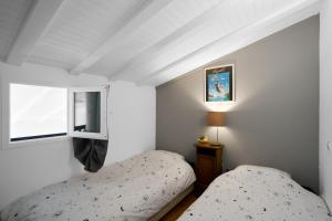 a bedroom with two twin beds and a window at Maison Séjour Capraisien in Saint-Capraise-de-Lalinde