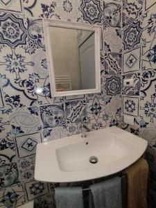 a white sink in a bathroom with blue and white tiles at L' Elicriso in Marciana