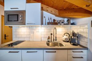 a kitchen with a sink and a microwave at Mountain Residence Kasern Nr 5 in Predoi +12 photos