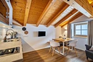 a kitchen and dining room with a table and chairs at Mountain Residence Kasern Nr 5 in Predoi