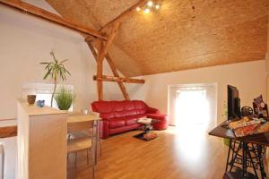 a living room with a red couch and a table at Alter Stall in Melzow +21 photos