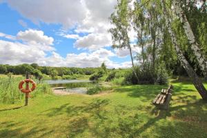 a park with a bench next to a river at Alter Stall in Melzow