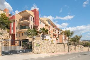 a building with a stone wall and palm trees at El Mirador in Mutxamel