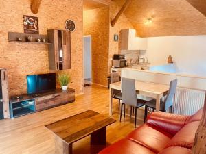 a living room with a dining table and a kitchen at Alter Stall in Melzow