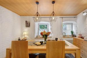 a dining room with a table with a vase of flowers at Ferienhaus Alte Wognerei in Fuchsmühl