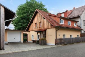 a house with a wooden roof and a garage at Ferienhaus Alte Wognerei in Fuchsmühl
