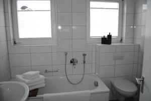 a bathroom with a tub and a toilet and a sink at Ferienhaus Joos in Uhldingen-Mühlhofen +19 photos