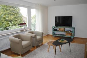 a living room with two chairs and a flat screen tv at Ferienhaus Joos in Uhldingen-Mühlhofen